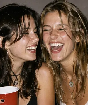 1990s disposable flash party candid with two friends laughing in a kitchen